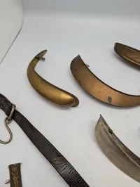 Samling af militære effekter, herunder hjelmdele, læderrem og emblemer