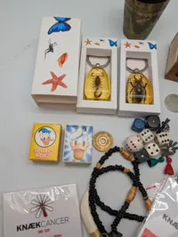 Samling af kuriositeter, herunder Knæk Cancer pins,  og spil