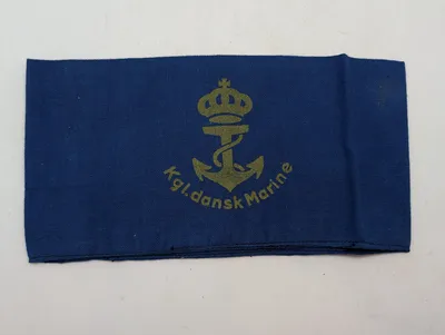WW2 Marine armbind Armbindet blev fremstillet til Den danske Brigades Flotille, men nåede ikke at blive udleveret. Anvendt af Søværnet en periode umiddelbart efter besættelsen.