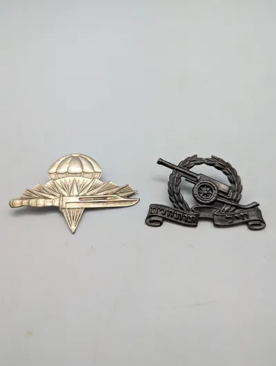 To israelske militære emblemer: Faldskærmstropper og Artillerikorps
