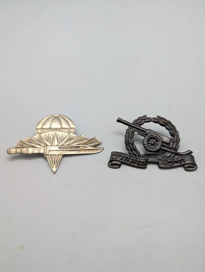 To israelske militære emblemer: Faldskærmstropper og Artillerikorps
