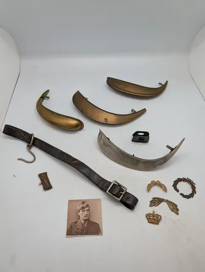 Samling af militære effekter, herunder hjelmdele, læderrem og emblemer