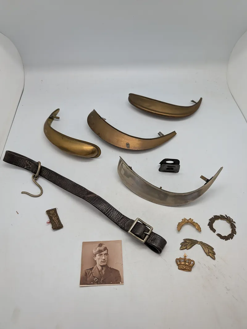 Samling af militære effekter, herunder hjelmdele, læderrem og emblemer