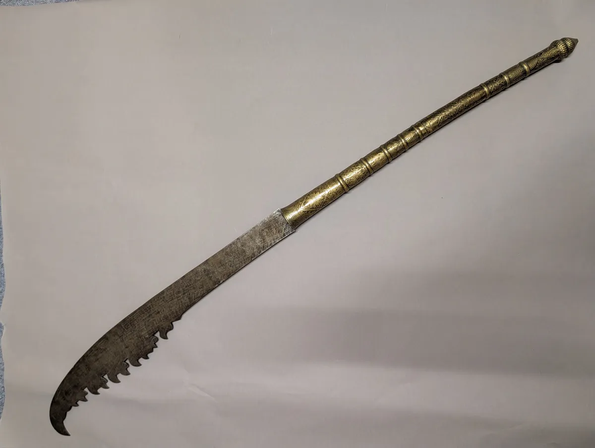 Antique Southeast Asian Dha Sword with Ornate Brass Hilt and Serrated Blade