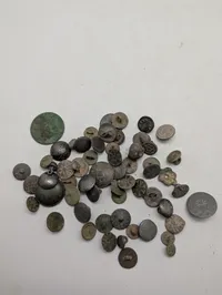 Samling af antikke og historiske metalknapper med dekorative motiver