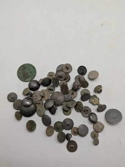 Samling af antikke og historiske metalknapper med dekorative motiver