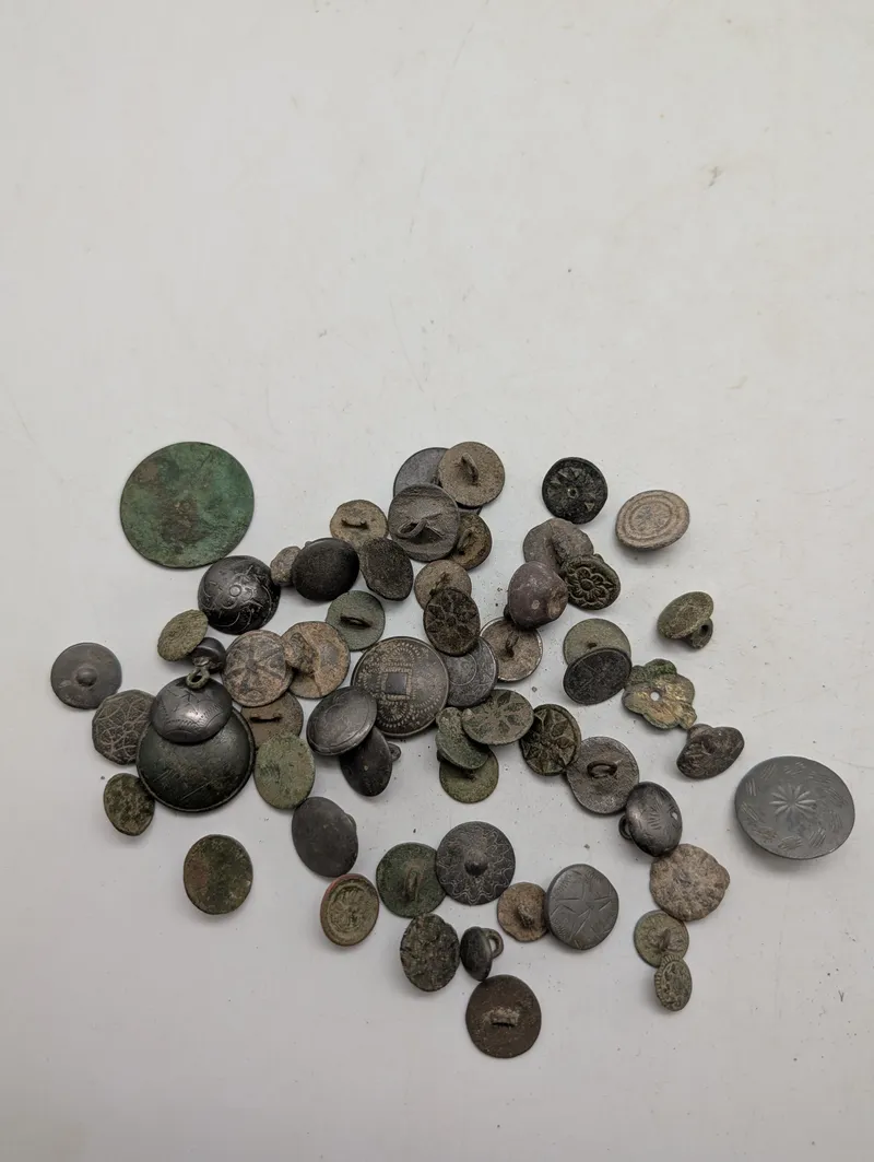 Samling af antikke og historiske metalknapper med dekorative motiver