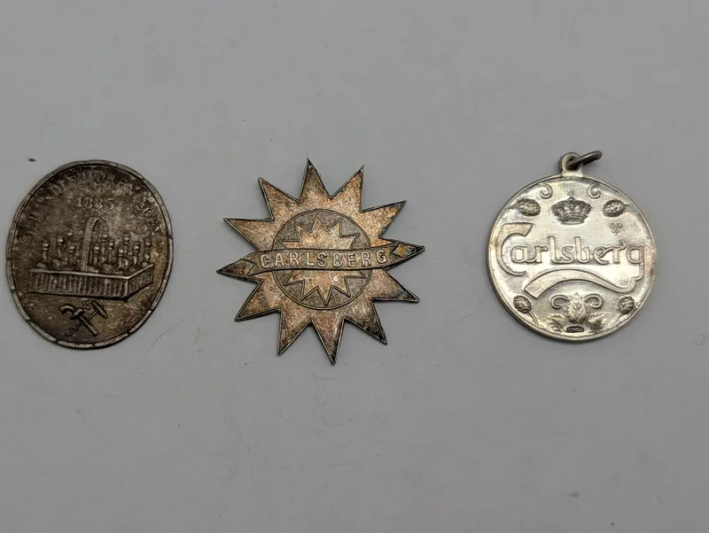 Samling af tre vintage Carlsberg-medaljer og emblemer Soltegn