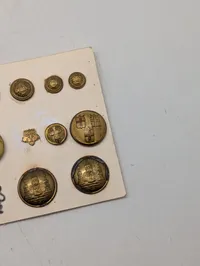 Samling af antikke og vintage militære knapper og emblemer