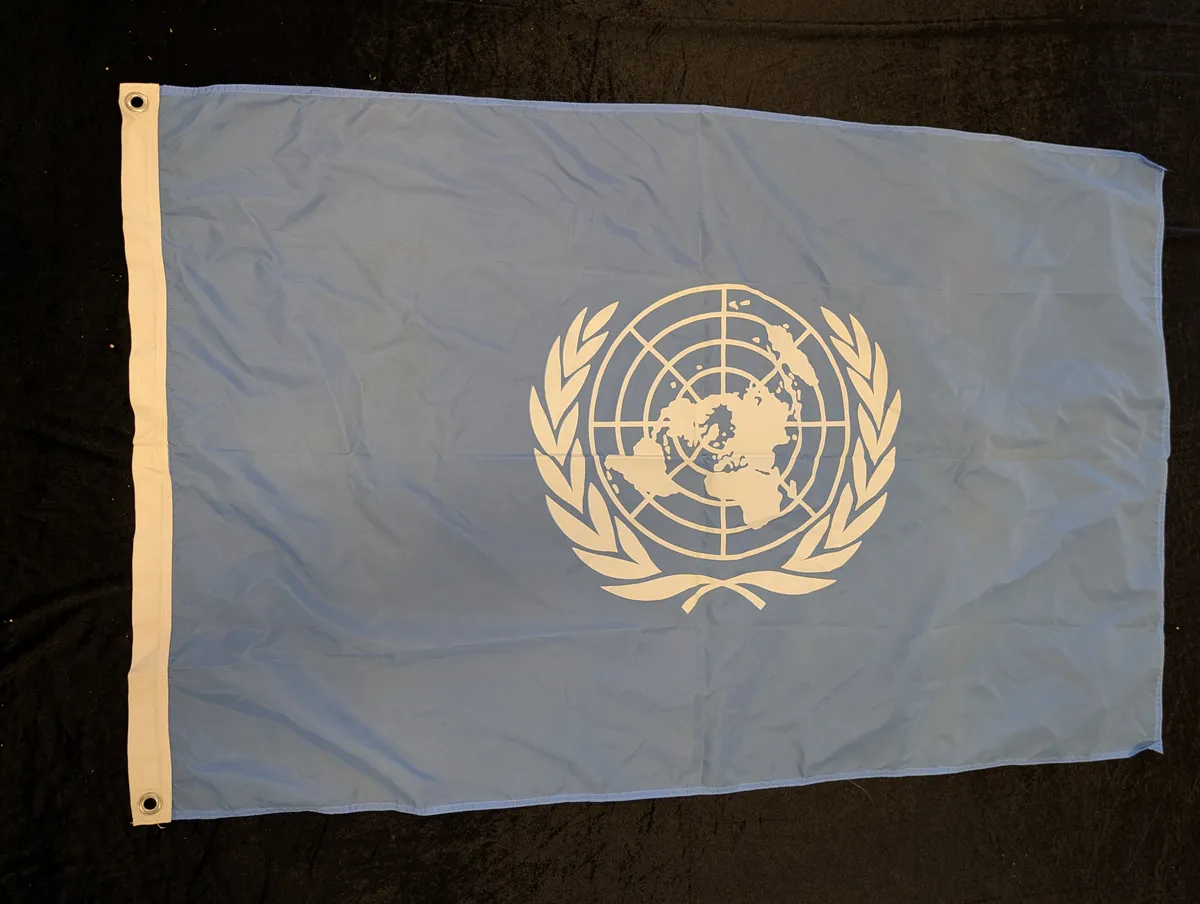 FN-flag i lyseblåt tekstil med hvidt emblem