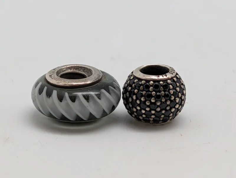 To Pandora charms i sterling sølv med Murano glas og sorte krystaller