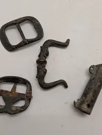 Samling af antikke bronzegenstande herunder spænder og rørformet beslag
