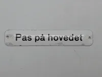 Emaljeskilt med teksten "Pas på hovedet" DSB