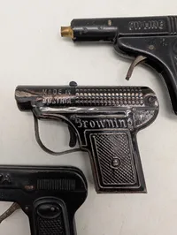 Tre antikke legetøjspistoler i metal, herunder O'les mains og D.R.G.M.