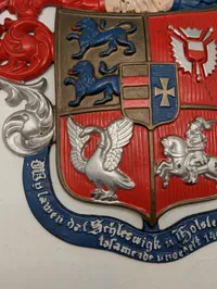 Støbejernsvåbenskjold med Slesvig-Holsten motiv og motto